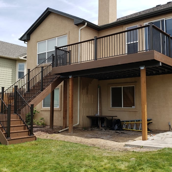 Tan House Featuring Dark Brown Wood Deck with Black Railing