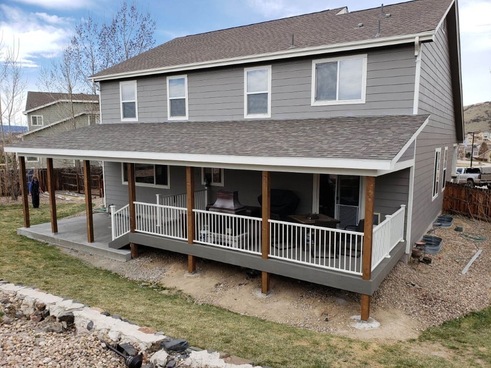 Gray home exterior in Colorado Springs with covered deck and porch by Black Diamond Decks