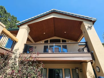 Raised covered deck with gabled roof design and recessed lighting by Black Diamond Decks in Colorado Springs