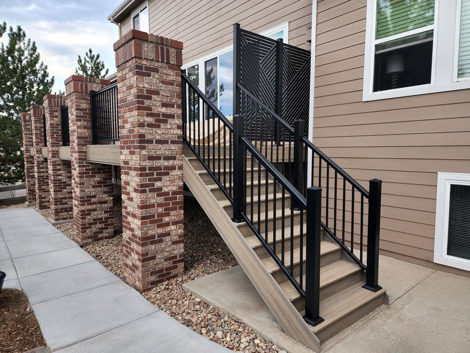 deck with stone pillars and iron stair railing
