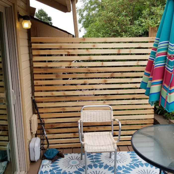 Wicker Chair in Front of Wooden Privacy Screen on Deck